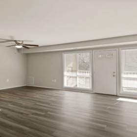 living room with oversized windows, ceiling fan and light fixture